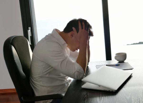 frustrated with problems young business man working on laptop computer at home