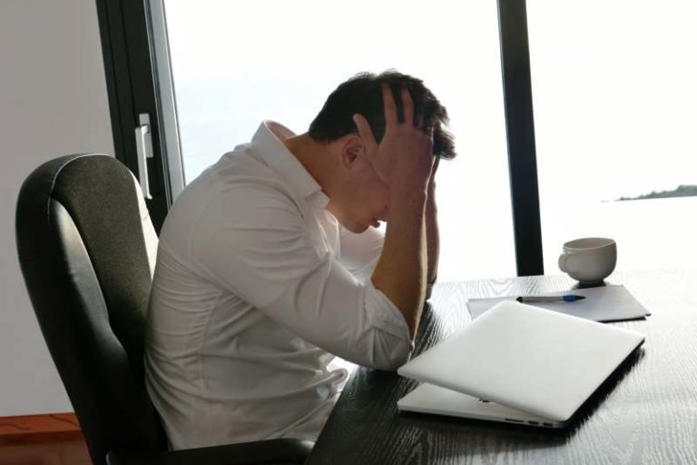 frustrated with problems young business man working on laptop computer at home